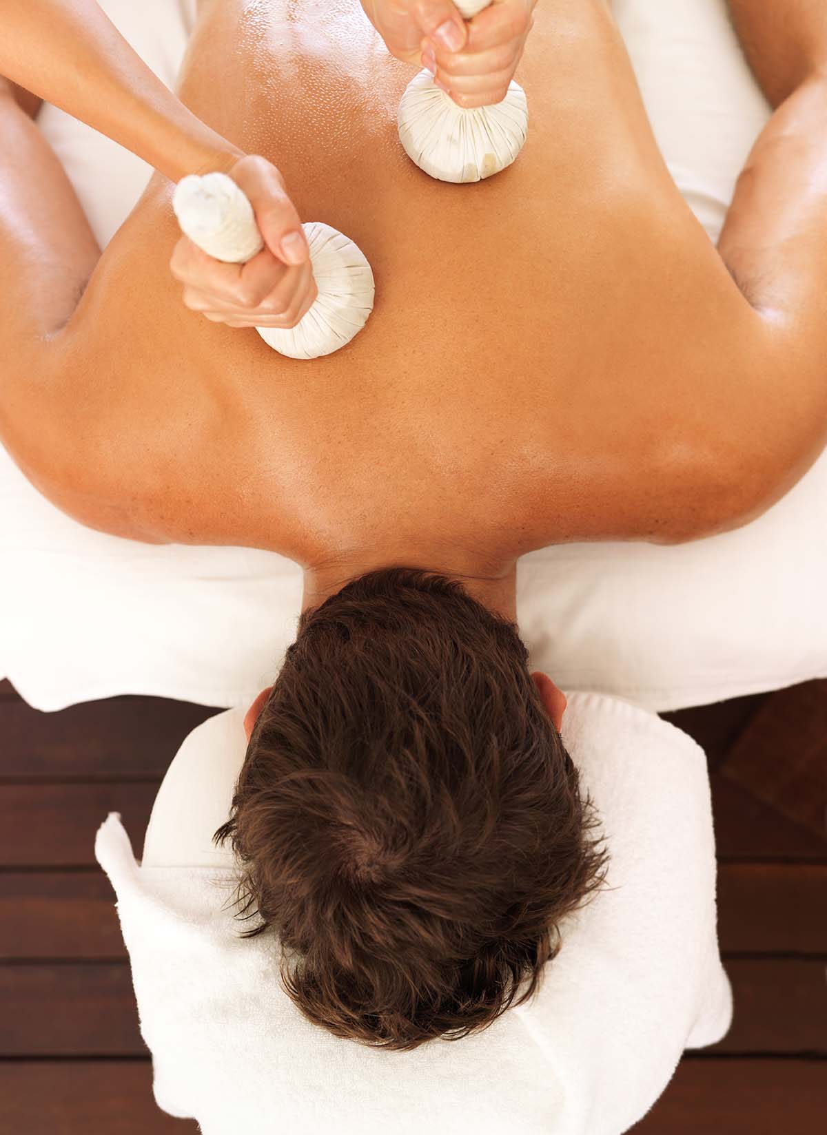 Focus on hands using massage tools to massage a man's back